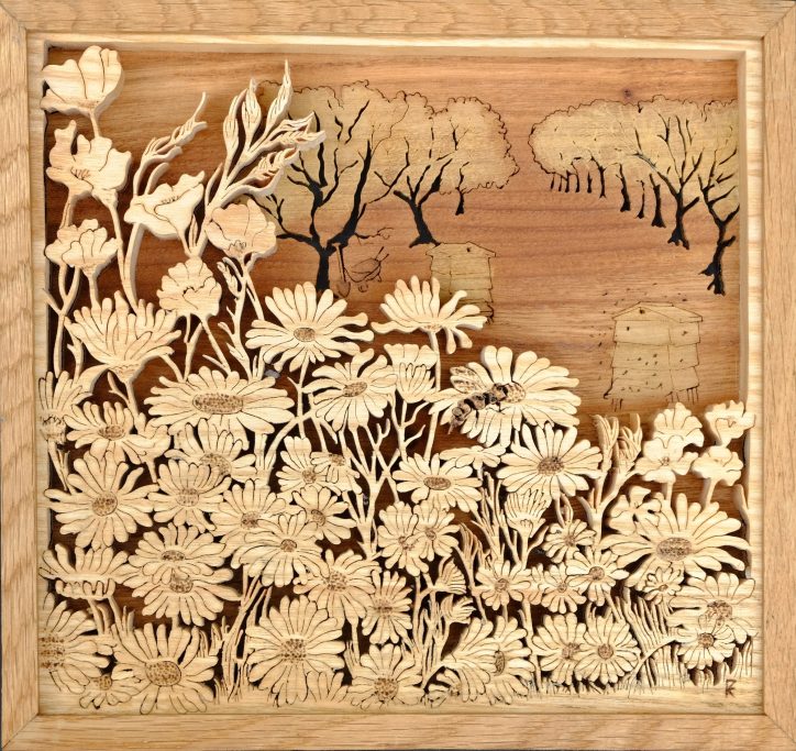 Intricate woodcut design depicting flowers and trees in a natural landscape.