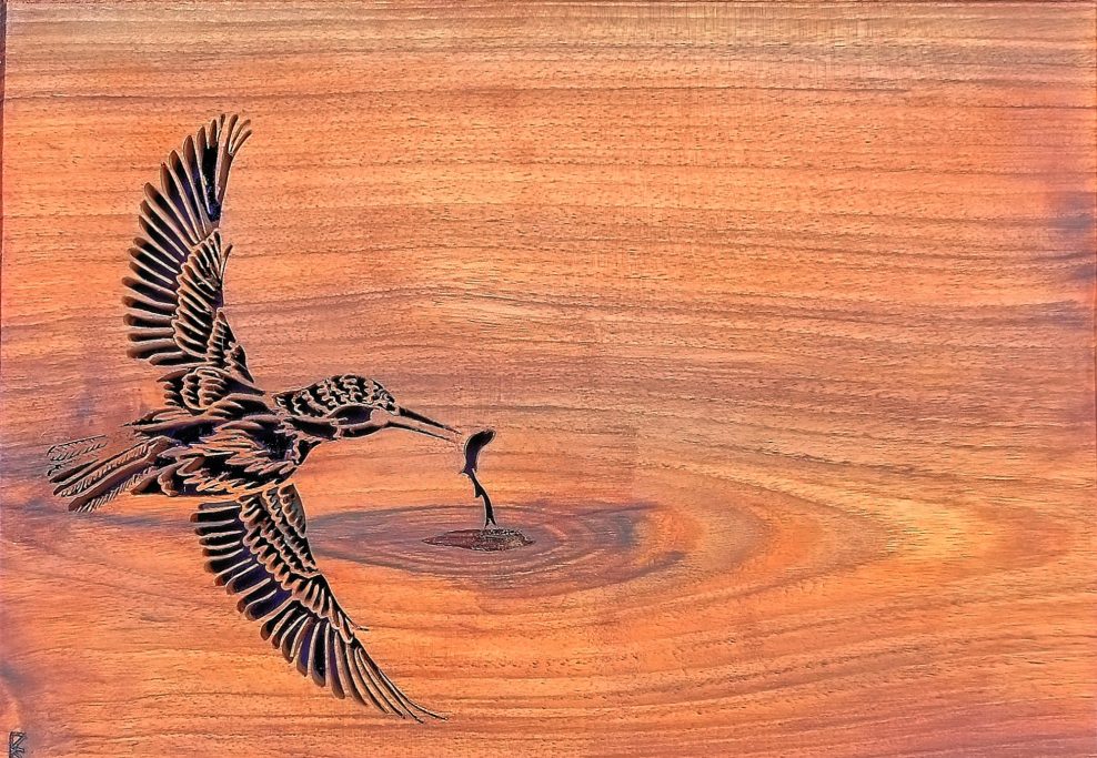 Wood picture silhouette of a kingfisher catching a fish