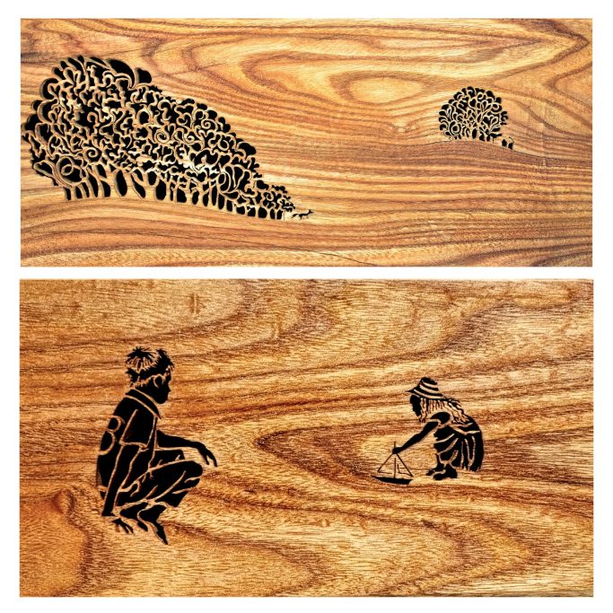 Wood picture silhouette featuring intricately cut and figures of children playing and a stylised tree landscape