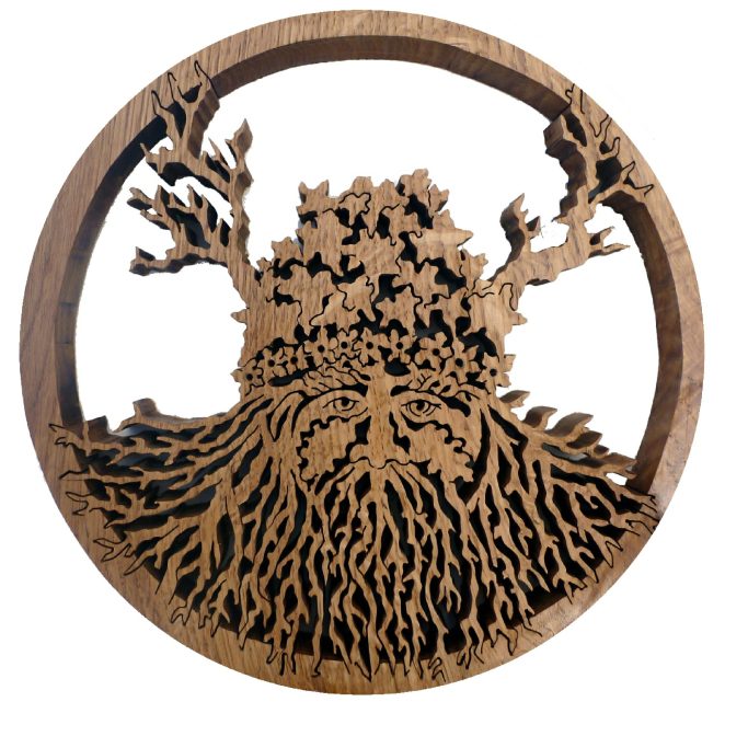 Wooden artwork depicting a viking style greenman with intricate roots and branches in a circular design.