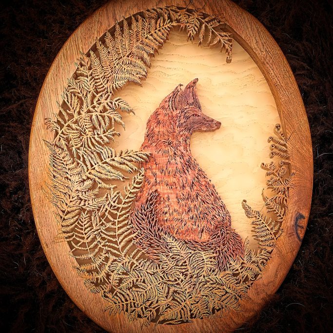 Wooden plaque featuring a fox surrounded by intricate fern patterns.