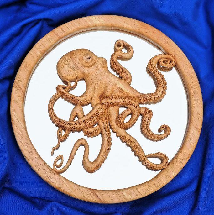 Carved wooden octopus design on a circular background with a blue cloth.