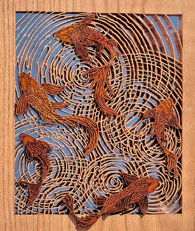 Carved wooden fish swimming among swirling patterns resembling water.