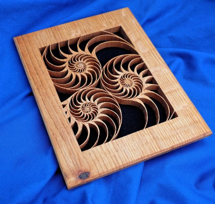 Threes shell shapes arranged in swirls pierced relief carving