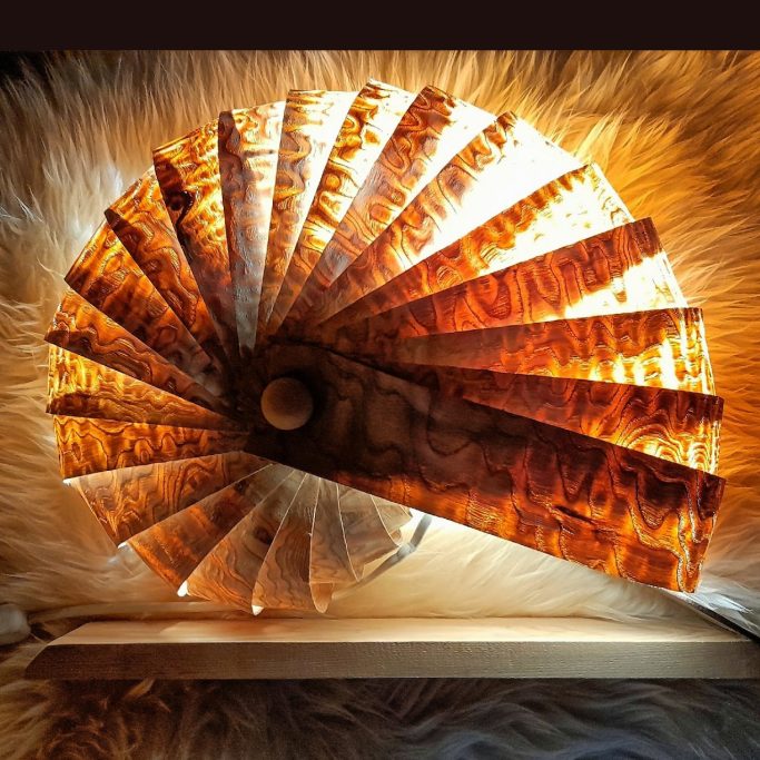 A decorative wood veneer lamp with intricate wood grain, illuminated from inside