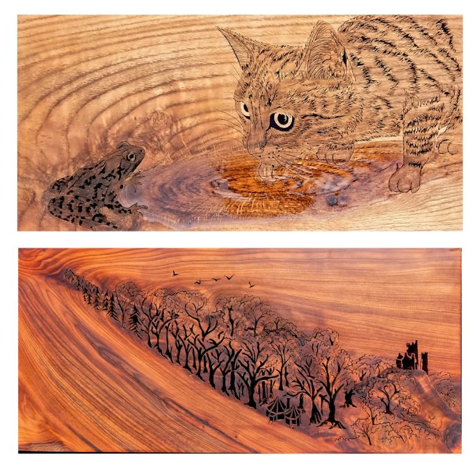 A wooden carving depicting a cat peering at a frog above a landscape of trees and a building.
