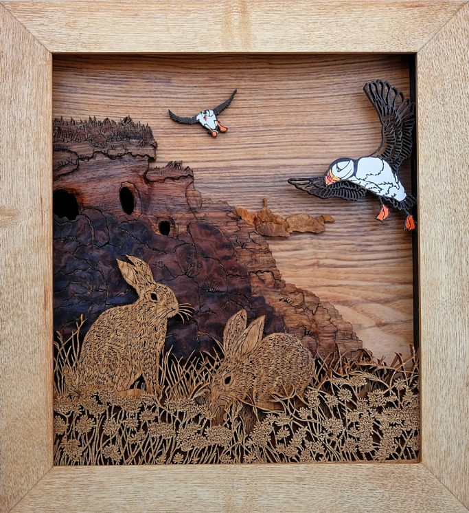 Wooden artwork featuring rabbits and birds in a natural setting.