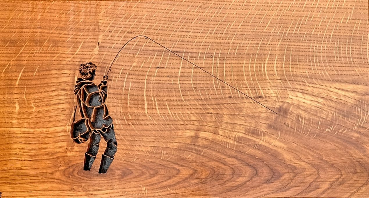Silhouette of a fisherman casting a line on wood grain