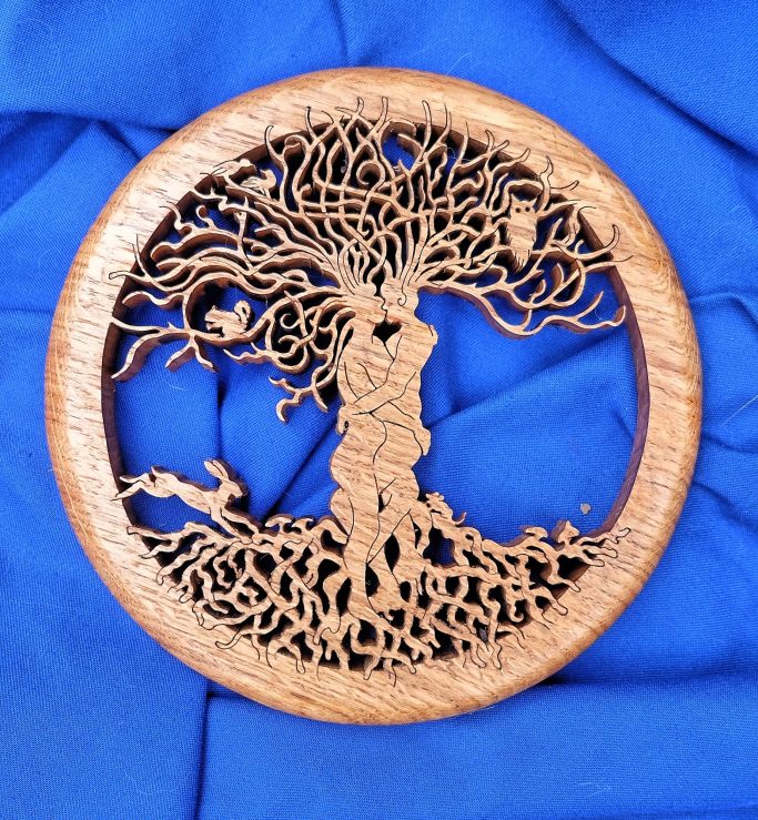 Pierced decorative wooden roundel depicting two intertwined bodies, vegetation and animals